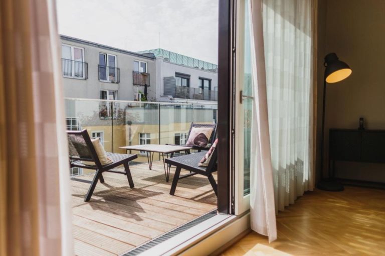 a balcony with chairs and a table and a window at The Circus Apartments in Berlin 768x512