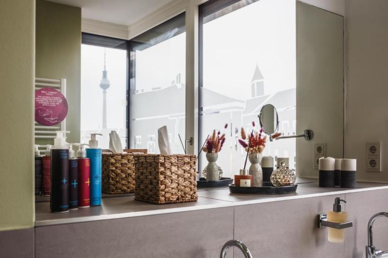 a bathroom counter with baskets and a window at The Circus Apartments in Berlin 768x512