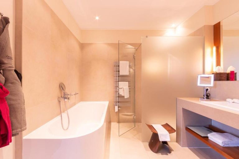 a bathroom with a bath tub and a sink at Orania.Berlin in Berlin 768x512
