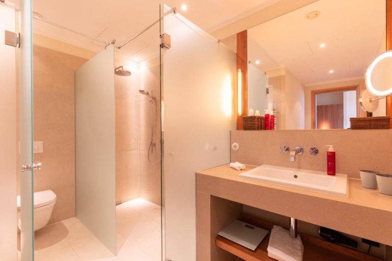 a bathroom with a shower and a sink and a toilet at Orania.Berlin in Berlin 768x512