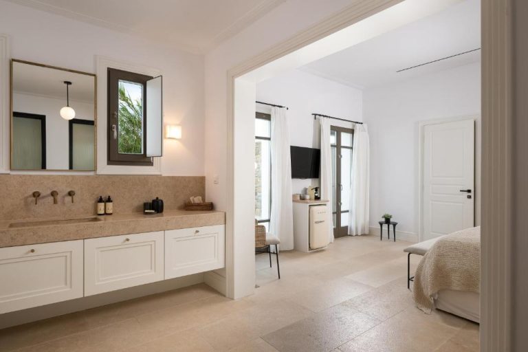 a bathroom with a sink and a mirror at Bonzoe Suites Villas in Mikonos 768x512