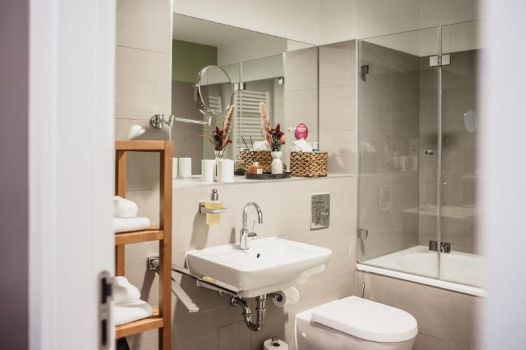 a bathroom with a sink and a toilet and a mirror at The Circus Apartments in Berlin 768x512