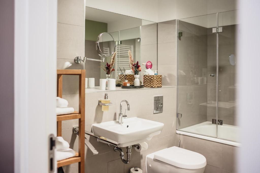 a bathroom with a sink and a toilet and a mirror at The Circus Apartments in Berlin