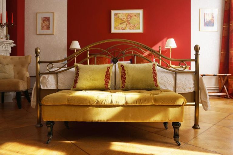 a bed with a gold bench in a room at Boutique Hotel Mittendrin Berlin in Berlin 768x512