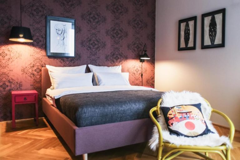 a bedroom with a bed and a chair at The Circus Apartments in Berlin 768x512