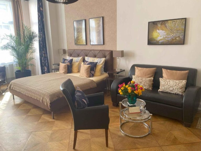 a bedroom with a bed and a couch and a chair at Boutique Hotel Mittendrin Berlin in Berlin 768x576
