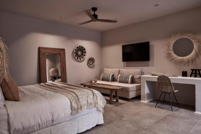 a bedroom with a bed and a couch at Amyth of Mykonos Agios Stefanos in Agios Stefanos 768x512