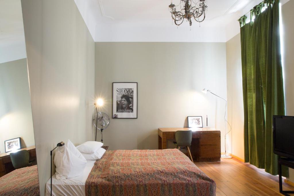 a bedroom with a bed and a desk and a television at Hotel Art Nouveau am Kurfurstendamm in Berlin