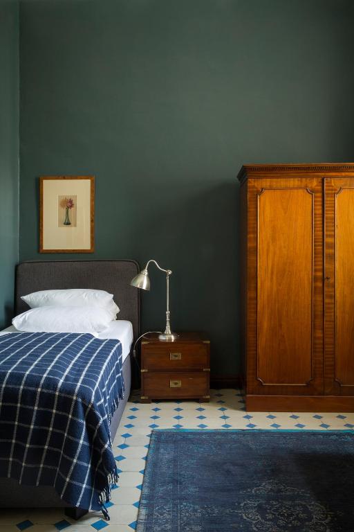 a bedroom with a bed and a lamp and a dresser at Hotel Art Nouveau am Kurfurstendamm in Berlin