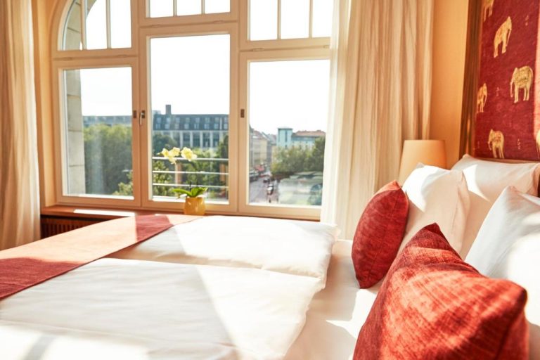 a bedroom with a bed and a large window at Orania.Berlin in Berlin 768x512
