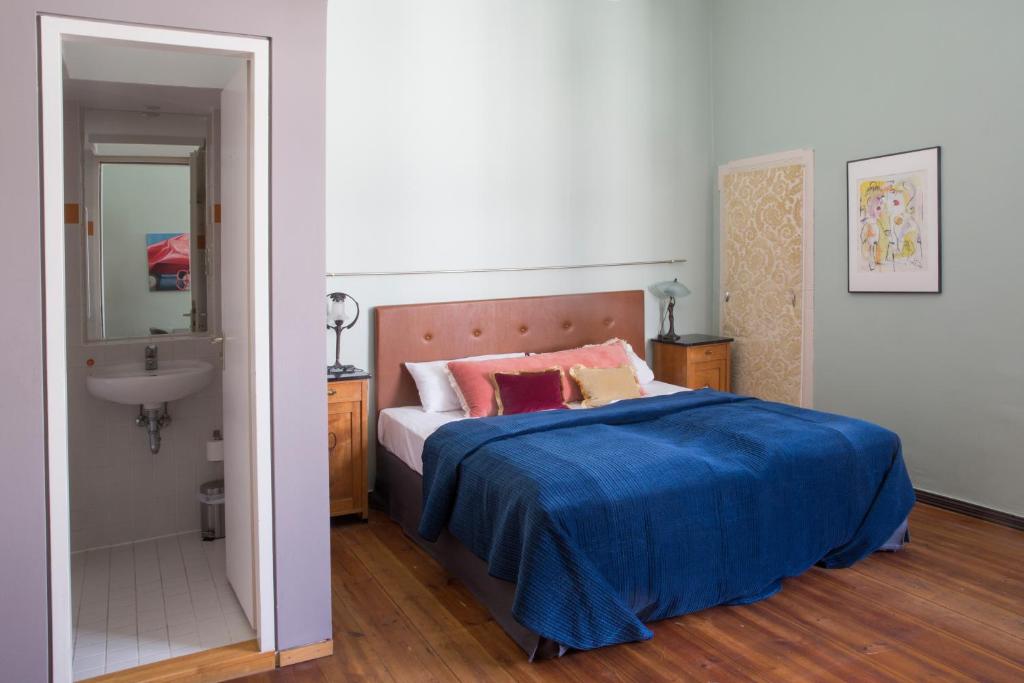a bedroom with a bed and a sink and a mirror at Hotel Art Nouveau am Kurfurstendamm in Berlin