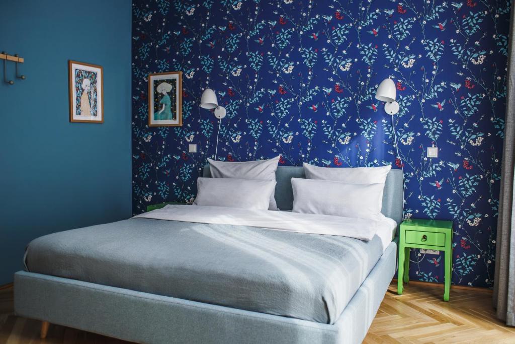 a bedroom with a bed with a blue wall at The Circus Apartments in Berlin