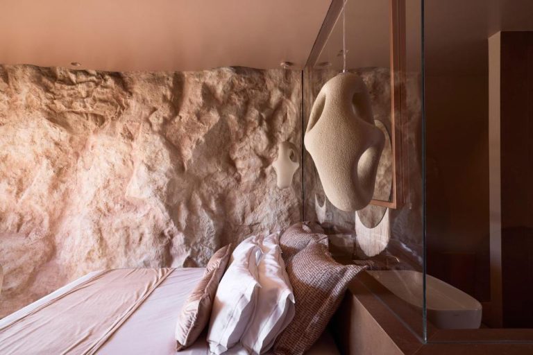 a bedroom with a bed with a stone wall at Ethereum Luxury Suites a member of Mykonos Highlights in Mikonos 768x512
