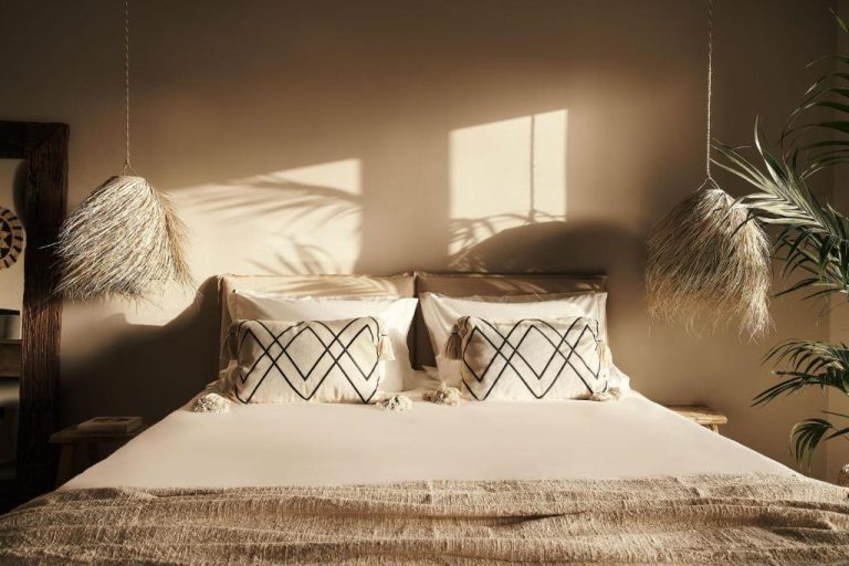 a bedroom with a bed with white sheets and pillows at Amyth of Mykonos Agios Stefanos in Agios Stefanos 768x512