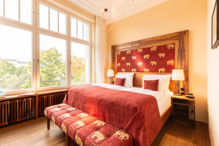 a bedroom with a large bed and a large window at Orania.Berlin in Berlin 768x512