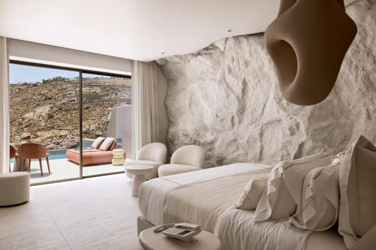 a bedroom with a large bed and a stone wall at Ethereum Luxury Suites a member of Mykonos Highlights in Mikonos 768x512