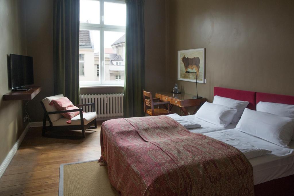 a bedroom with a large bed and a window at Hotel Art Nouveau am Kurfurstendamm in Berlin