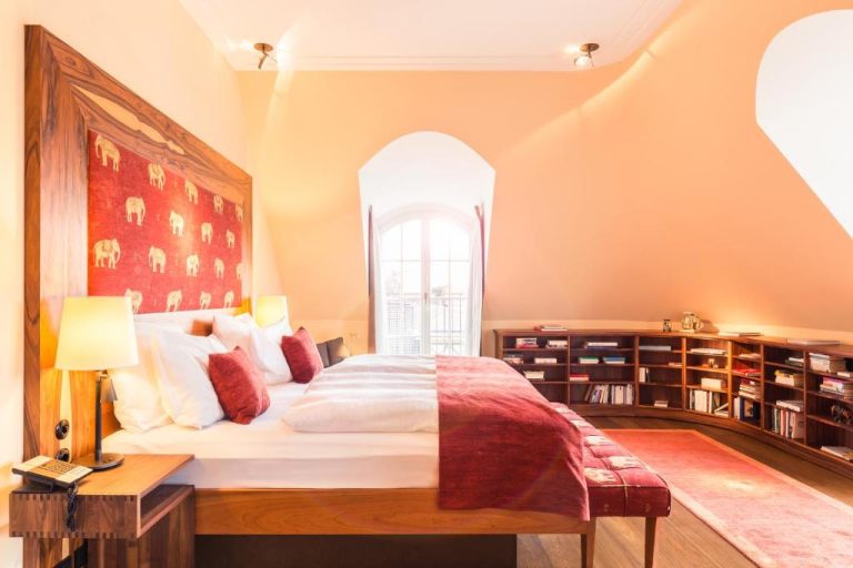 a bedroom with a large bed and bookshelves at Orania.Berlin in Berlin 768x512