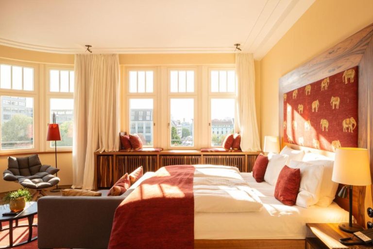 a bedroom with a large bed and windows at Orania.Berlin in Berlin 768x512