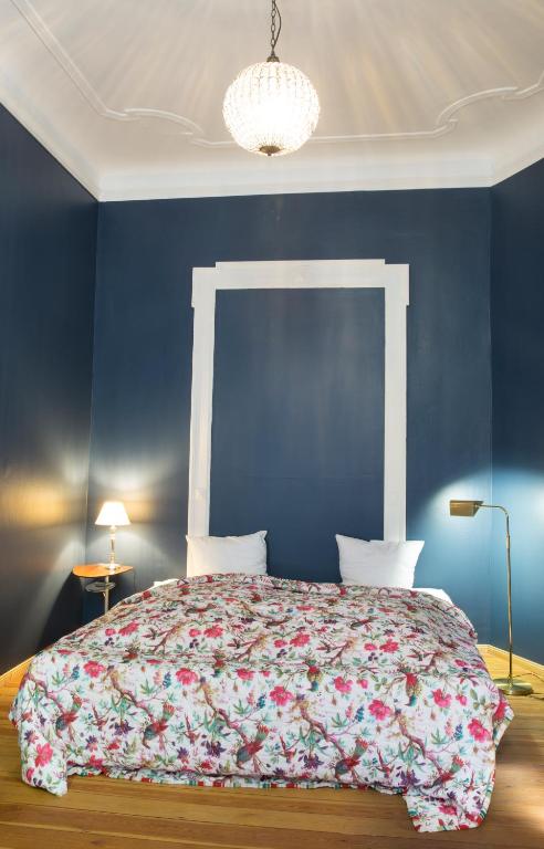 a bedroom with a large bed with a blue wall at Hotel Art Nouveau am Kurfurstendamm in Berlin