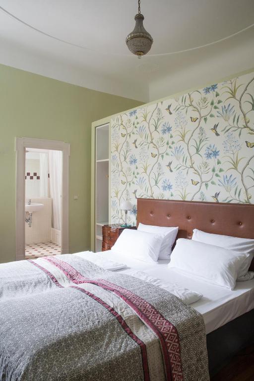 a bedroom with a large bed with a floral wallpaper at Hotel Art Nouveau am Kurfurstendamm in Berlin