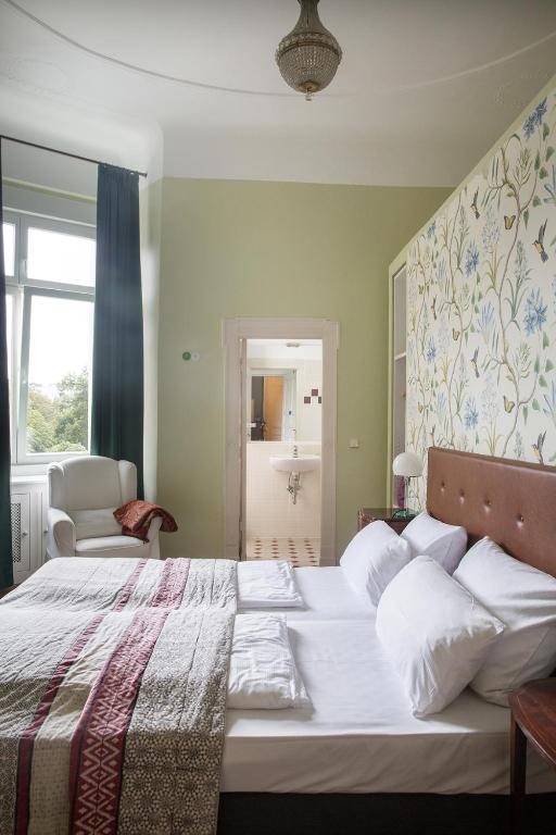 a bedroom with a large bed with white pillows at Hotel Art Nouveau am Kurfurstendamm in Berlin