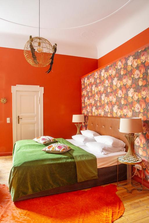a bedroom with orange walls and a bed with two lamps at Hotel Art Nouveau am Kurfurstendamm in Berlin