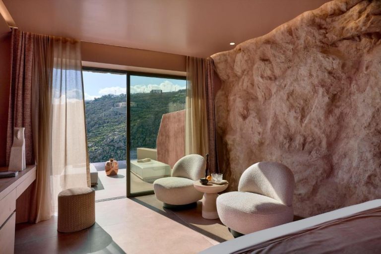 a bedroom with two chairs and a large window at Ethereum Luxury Suites a member of Mykonos Highlights in Mikonos 768x512