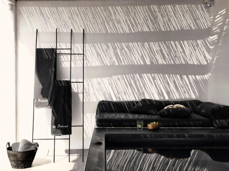 a black leather couch in a room with a wall at Boheme Mykonos Town Small Luxury Hotels of the World in Mikonos 768x575