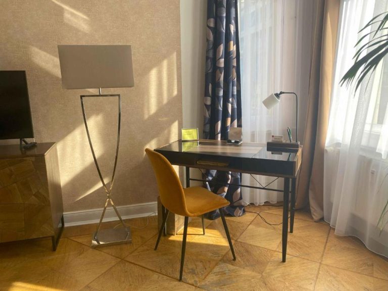 a desk with a chair and a lamp in a room at Boutique Hotel Mittendrin Berlin in Berlin 768x576