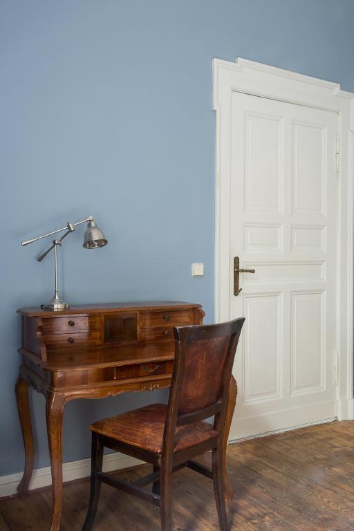 a desk with a lamp and a chair next to a door at Hotel Art Nouveau am Kurfurstendamm in Berlin