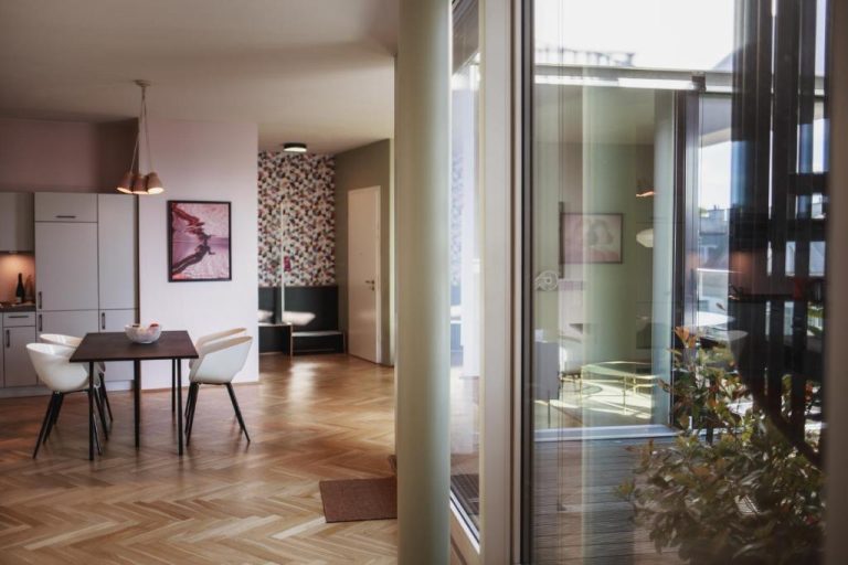 a dining room and living room with a table and chairs at The Circus Apartments in Berlin 768x512
