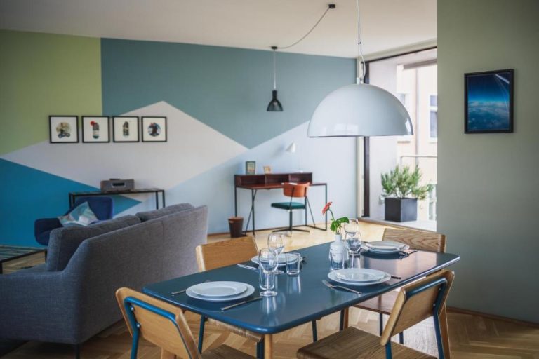 a dining room with a blue table and chairs at The Circus Apartments in Berlin 768x512