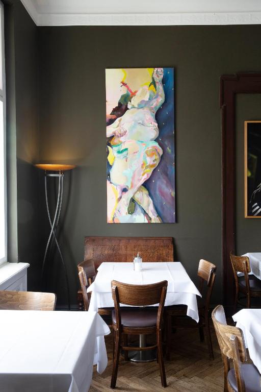 a dining room with a table and a painting on the wall at Hotel Art Nouveau am Kurfurstendamm in Berlin