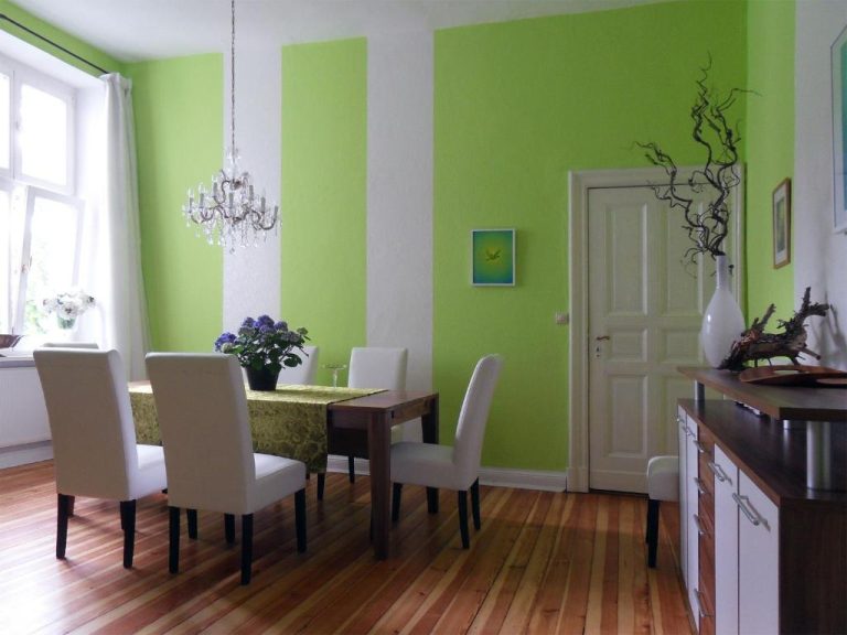 a dining room with green walls and a table and chairs at Boutique Hotel Mittendrin Berlin in Berlin 768x576