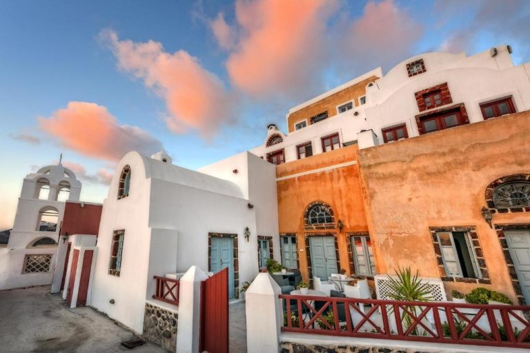 a group of buildings with a church in the background at Aigialos Luxury Traditional Settlement in Fira 768x512
