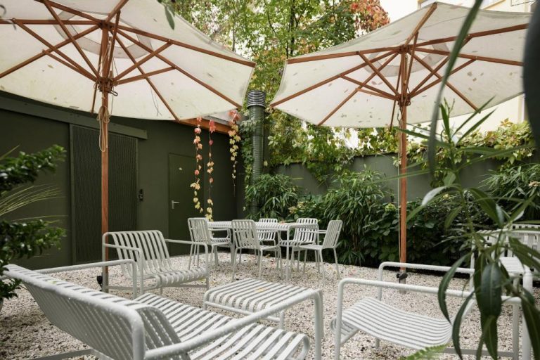 a group of chairs and tables with umbrellas at ADELANTE Boutique Hotel in Berlin 768x512