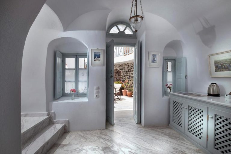 a hallway with white walls and an open door at Aigialos Luxury Traditional Settlement in Fira 768x512