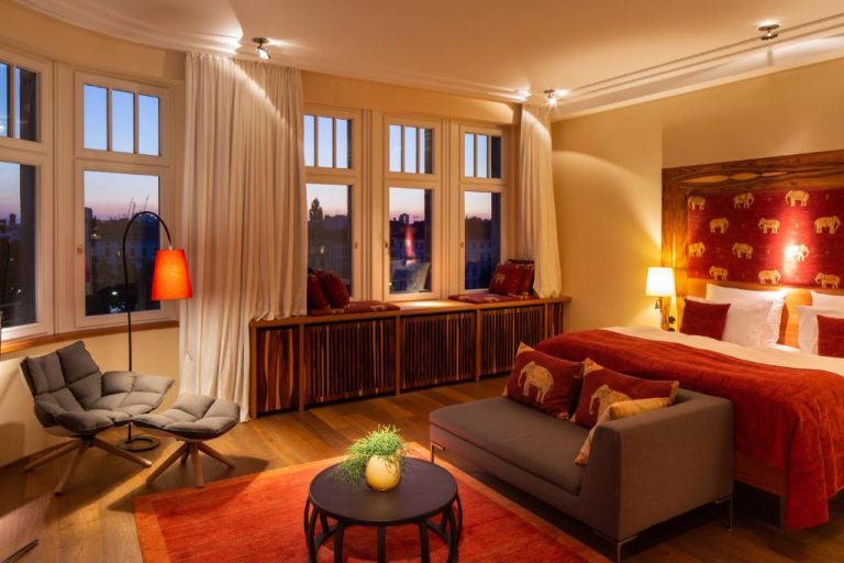 a hotel room with a bed and a chair at Orania.Berlin in Berlin 768x512