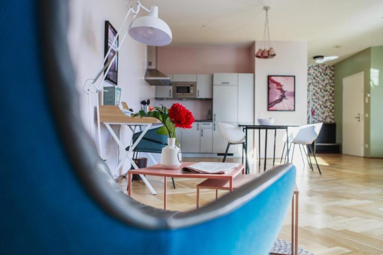 a living room and kitchen with a blue couch at The Circus Apartments in Berlin 768x512