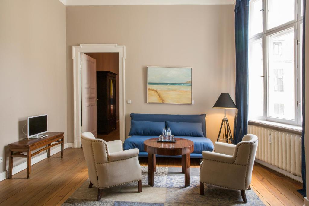 a living room with a blue couch and chairs at Hotel Art Nouveau am Kurfurstendamm in Berlin