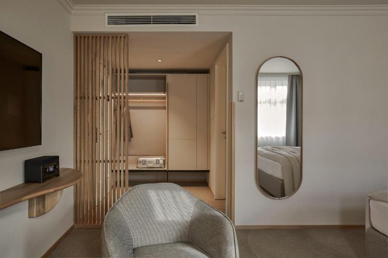 a living room with a chair and a mirror at ADELANTE Boutique Hotel in Berlin 768x512