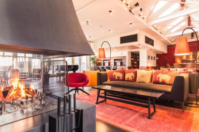a living room with a couch and a fireplace at Orania.Berlin in Berlin 768x512