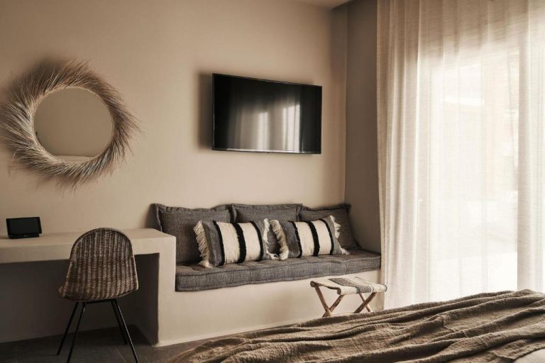 a living room with a couch and a mirror at Amyth of Mykonos Agios Stefanos in Agios Stefanos 768x512