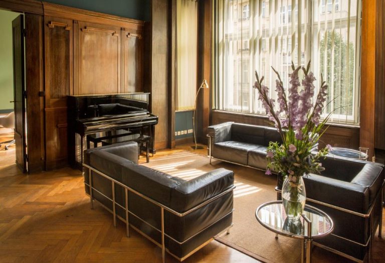 a living room with a couch and a piano at Hotel Art Nouveau am Kurfurstendamm in Berlin 768x525