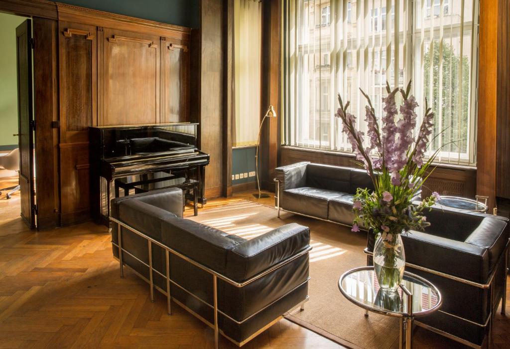 a living room with a couch and a piano at Hotel Art Nouveau am Kurfurstendamm in Berlin