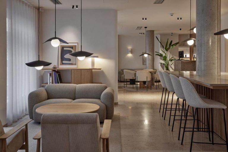 a living room with a couch and a table and chairs at ADELANTE Boutique Hotel in Berlin 768x512
