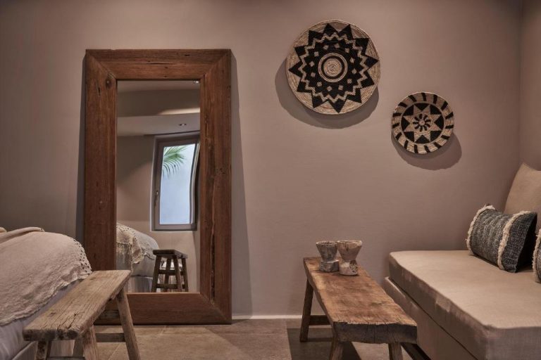 a living room with a mirror and a couch at Amyth of Mykonos Agios Stefanos in Agios Stefanos 768x512