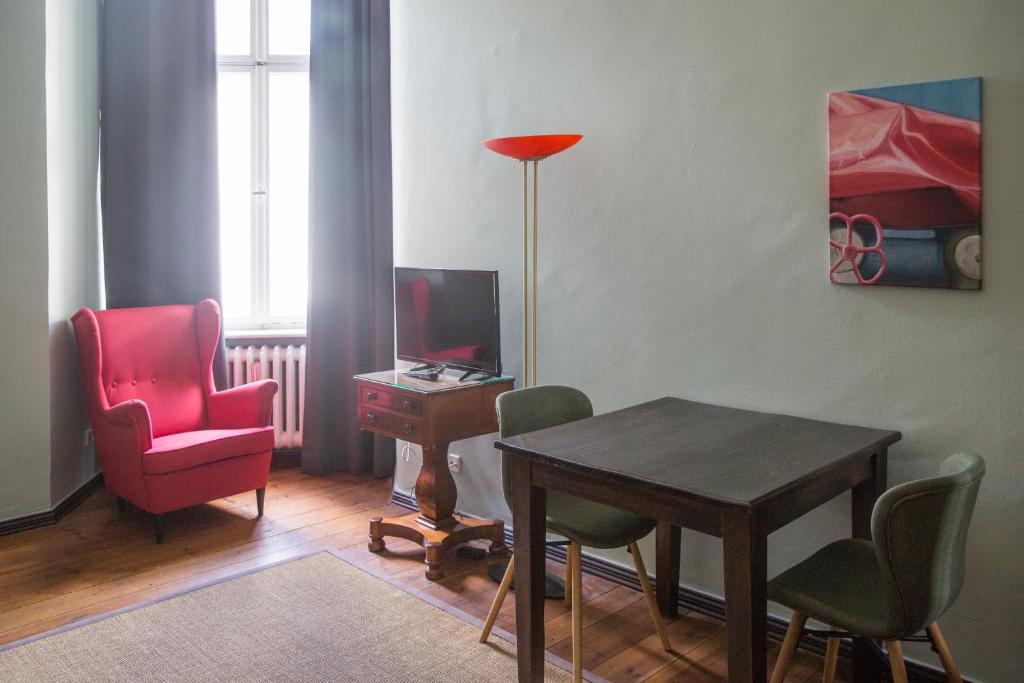 a living room with a table and chairs and a lamp at Hotel Art Nouveau am Kurfurstendamm in Berlin