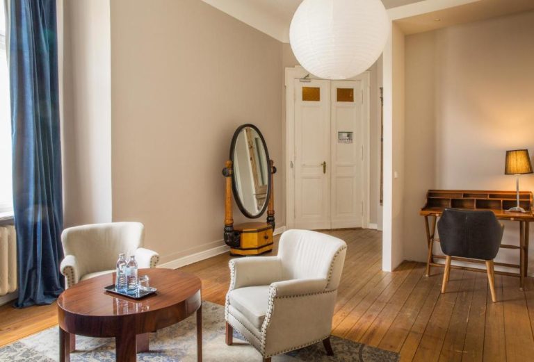 a living room with a table and chairs and a mirror at Hotel Art Nouveau am Kurfurstendamm in Berlin 768x521